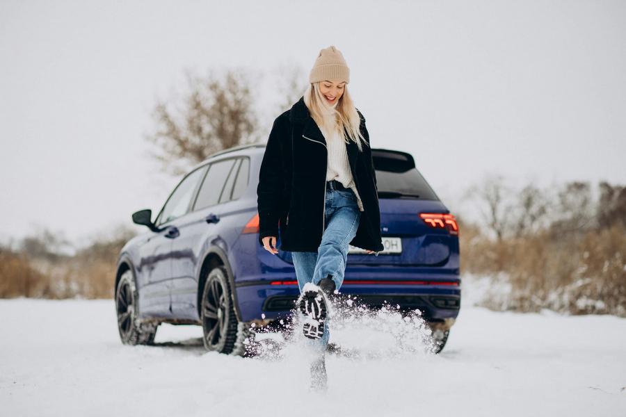 Девушка зимой около машины